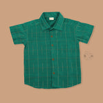 Green silk checked shirt with white dhoti featuring golden border – traditional South Indian boys ethnic wear set by Boon Babies.
