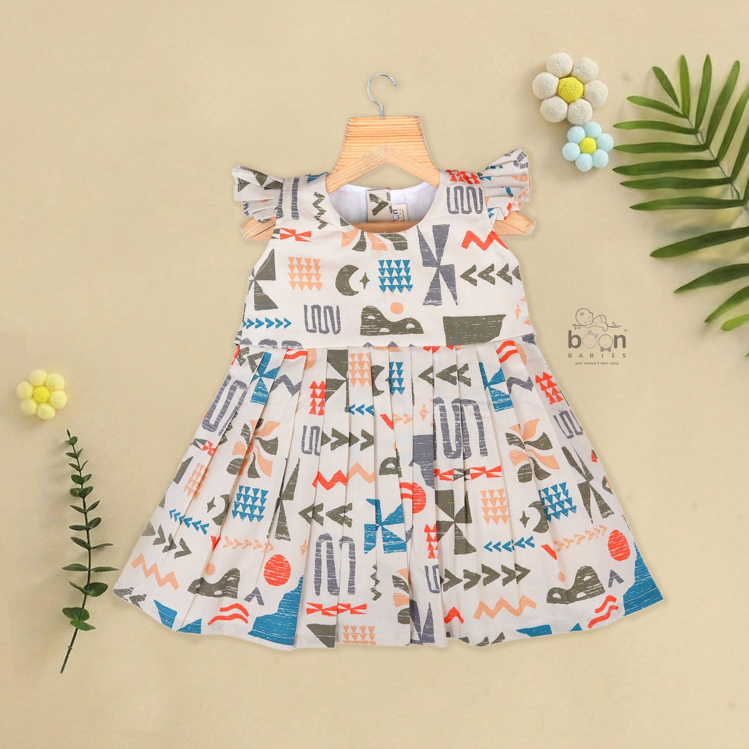Soft cotton frock for girls featuring multicolor geometric prints and flutter sleeves. Available in sizes 6 months to 5 years. Made in Coimbatore.
