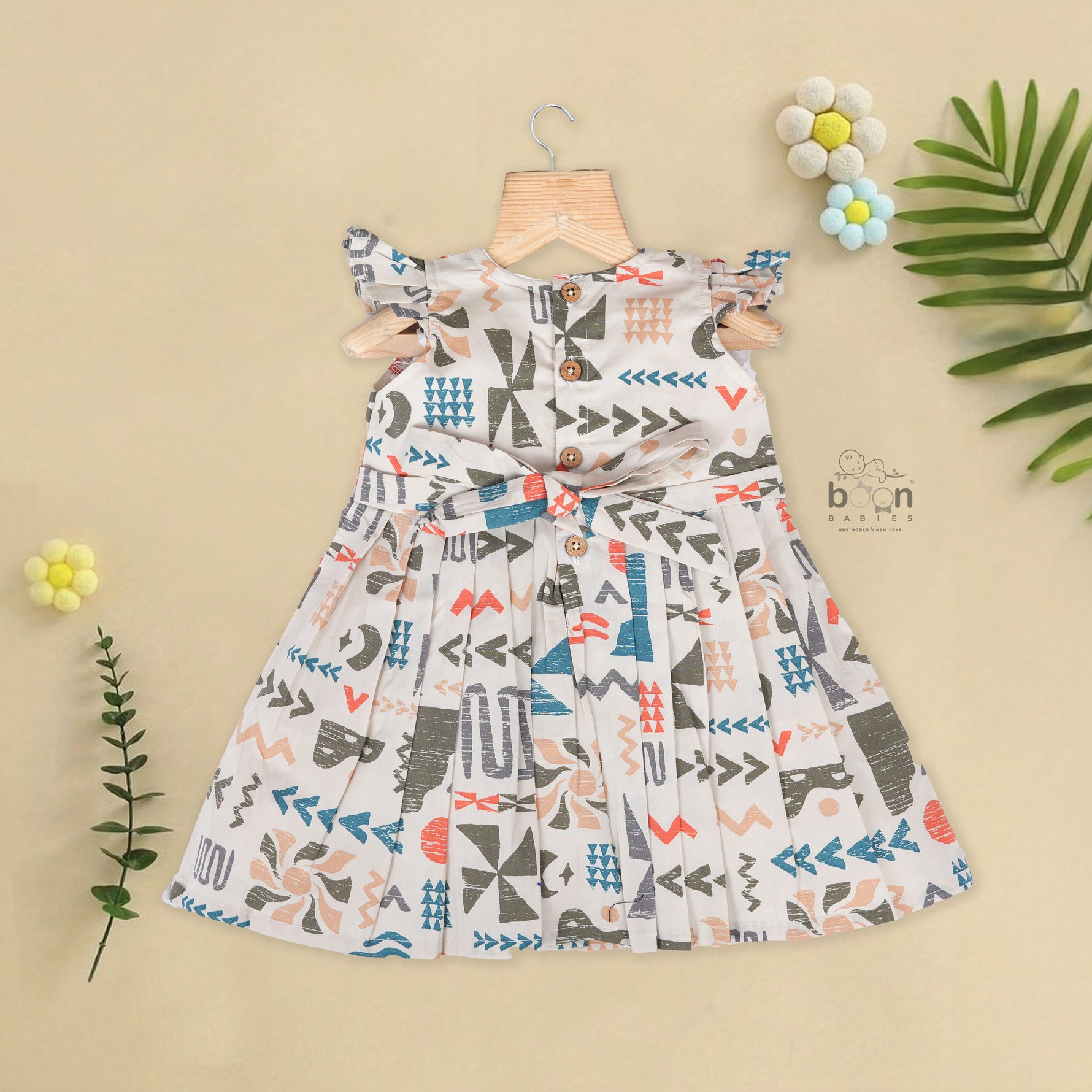 Soft cotton frock for girls featuring multicolor geometric prints and flutter sleeves. Available in sizes 6 months to 5 years. Made in Coimbatore.
