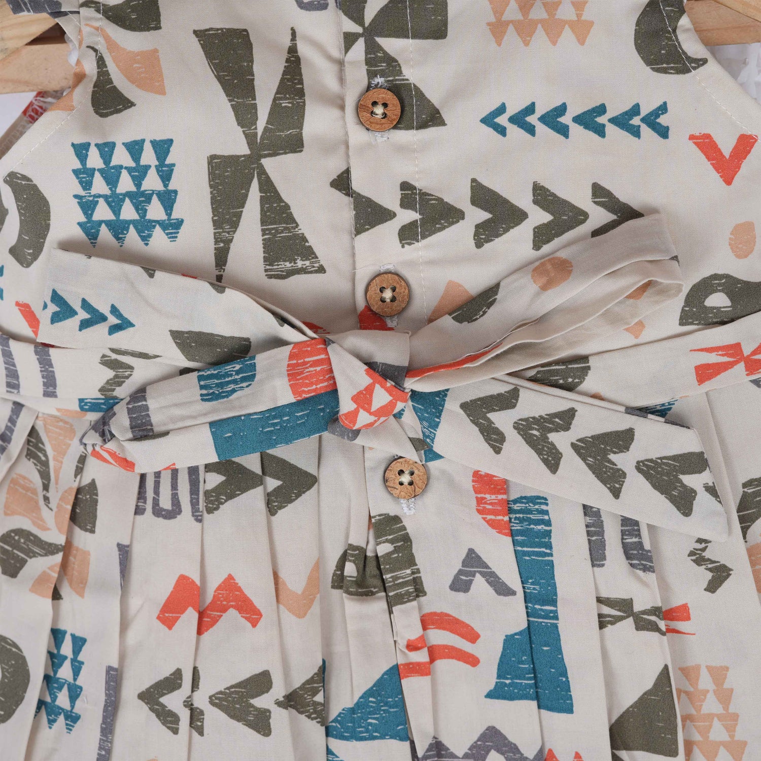 Soft cotton frock for girls featuring multicolor geometric prints and flutter sleeves. Available in sizes 6 months to 5 years. Made in Coimbatore.
