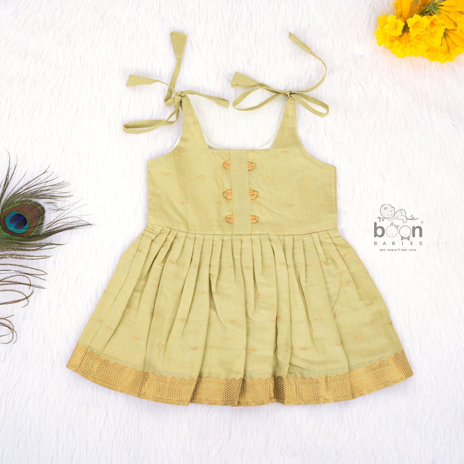 Olive green silk knot frock with zari border for baby girls (0–12 months). Festive, elegant & comfortable for Onam celebrations.

