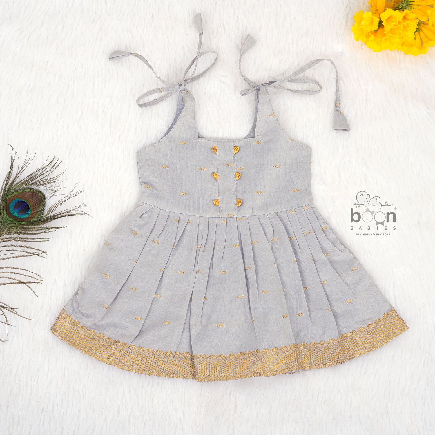 Grey silk knot frock with zari border & pleated design for baby girls (0–12 months). Stylish, festive & comfortable.
