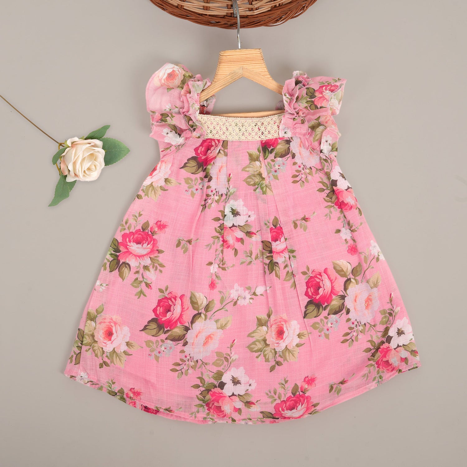 Chic dark pink linen frock with floral prints and ruffle sleeves. Sizes 6M–4Y. Ideal for festive and daily moments.
