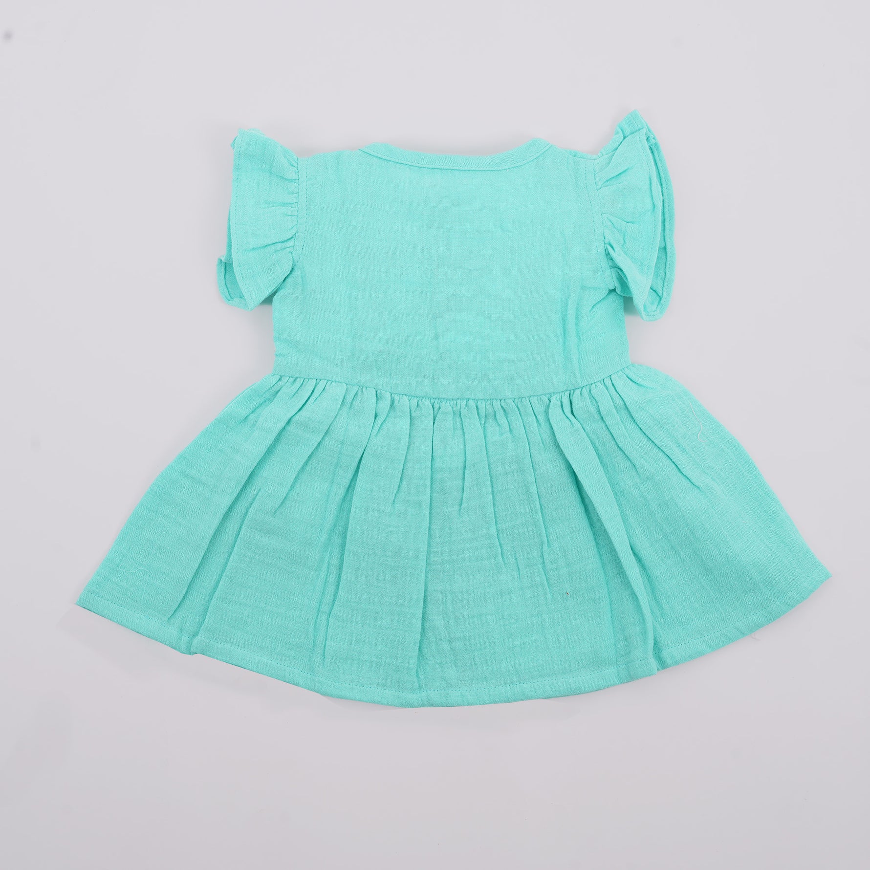 Mint green crinkled muslin frill frock for baby girls by Boon Babies, shown from the back with ruffled details and soft fabric.