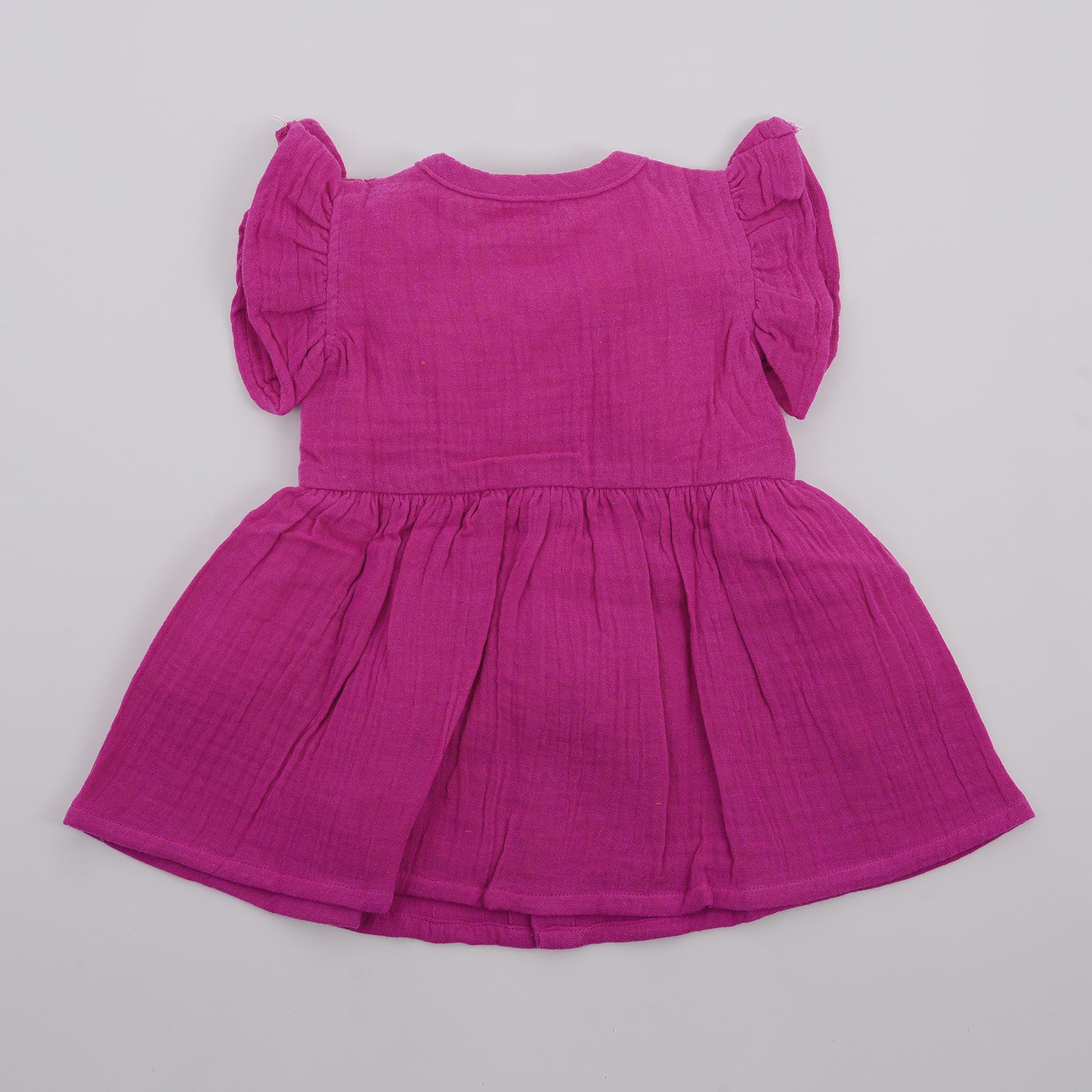 Solid magenta crinkled muslin frill frock for baby girls.