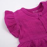 Baby girl wearing a Magenta Purple Crinkled Muslin Solid Frill Frock by Boon Babies, featuring ruffled details and soft fabric.