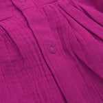Baby girl in a magenta purple crinkled muslin solid frill frock by Boon Babies, showing the textured fabric and ruffled detail.