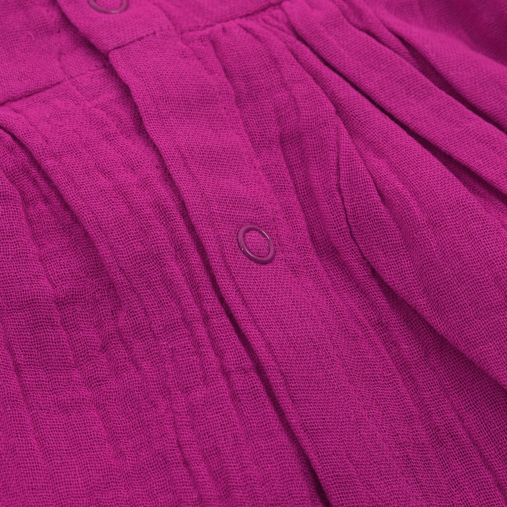 Baby girl in a magenta purple crinkled muslin solid frill frock by Boon Babies, showing the textured fabric and ruffled detail.