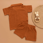 Rust brown boys’ shirt and shorts set made of soft crinkled muslin, with lion patch embroidery and wooden buttons – summer co-ord from Boon Babies.
