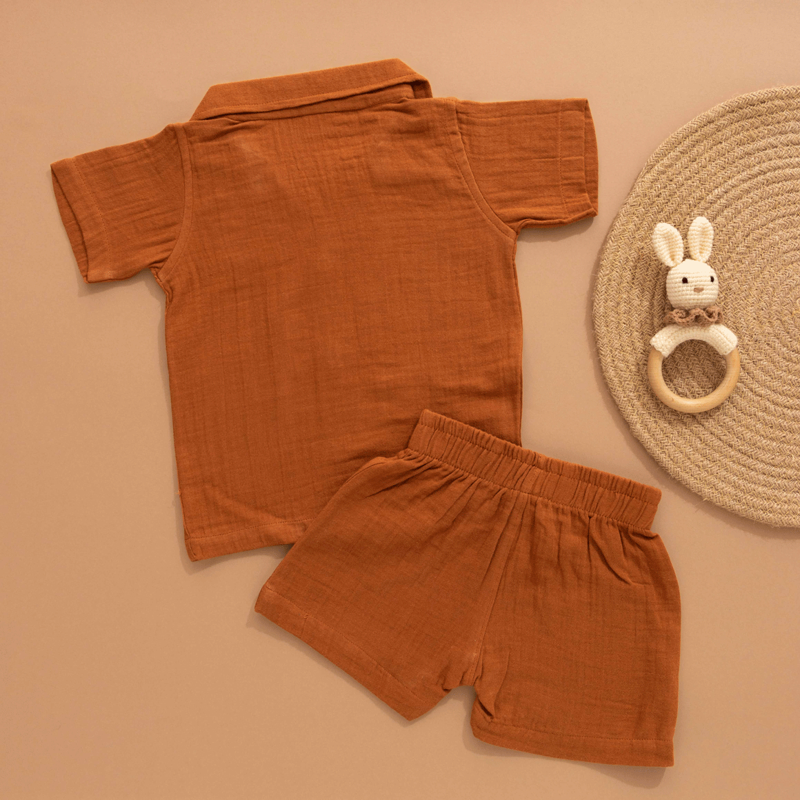 Rust brown boys’ shirt and shorts set made of soft crinkled muslin, with lion patch embroidery and wooden buttons – summer co-ord from Boon Babies.
