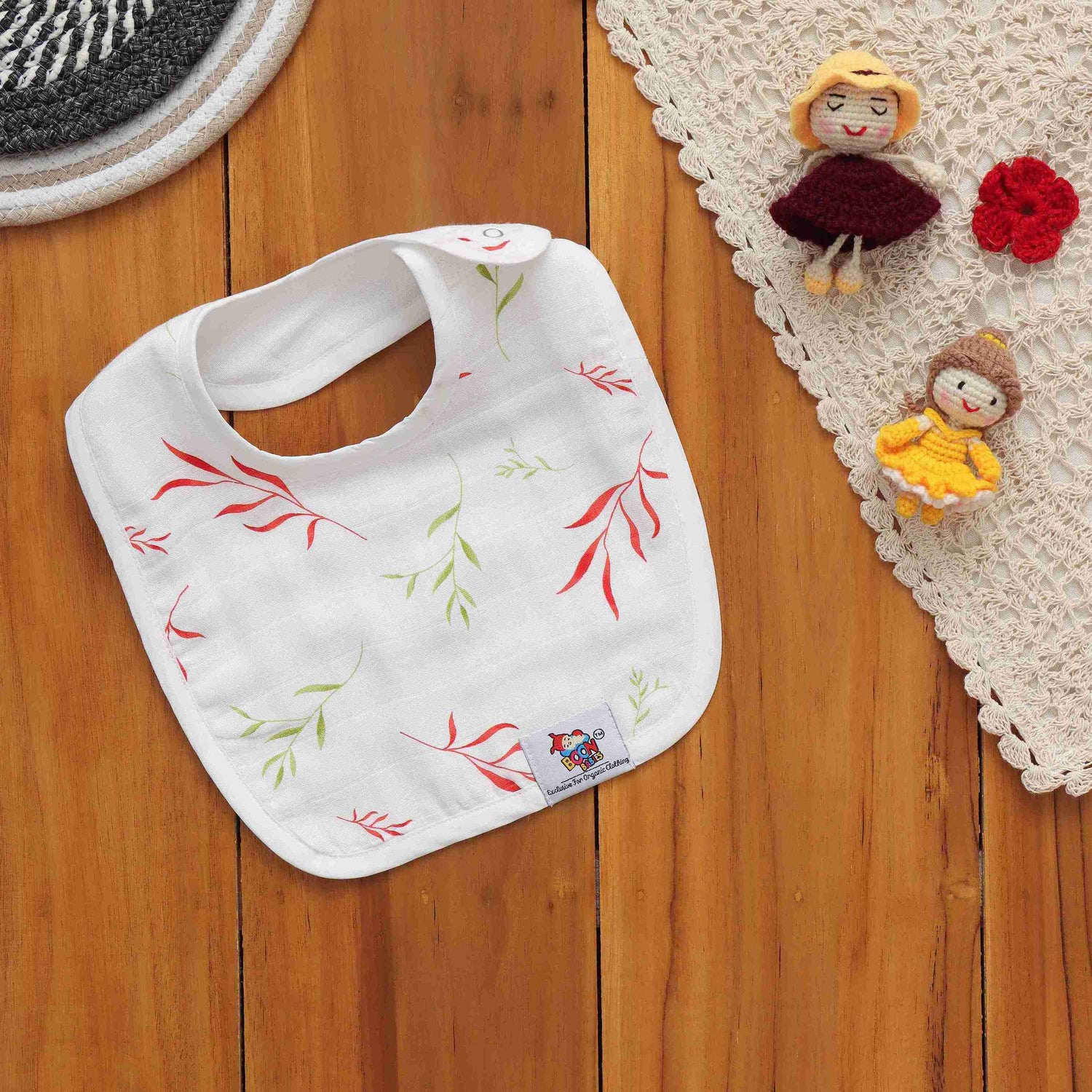 Breathable muslin baby bib with leafy print and snap closure. Skin-friendly and perfect for daily mess-free moments.