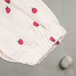 Baby girl wearing a printed muslin romper with frill sleeves by Boon Babies, showcasing soft fabric and cute design.