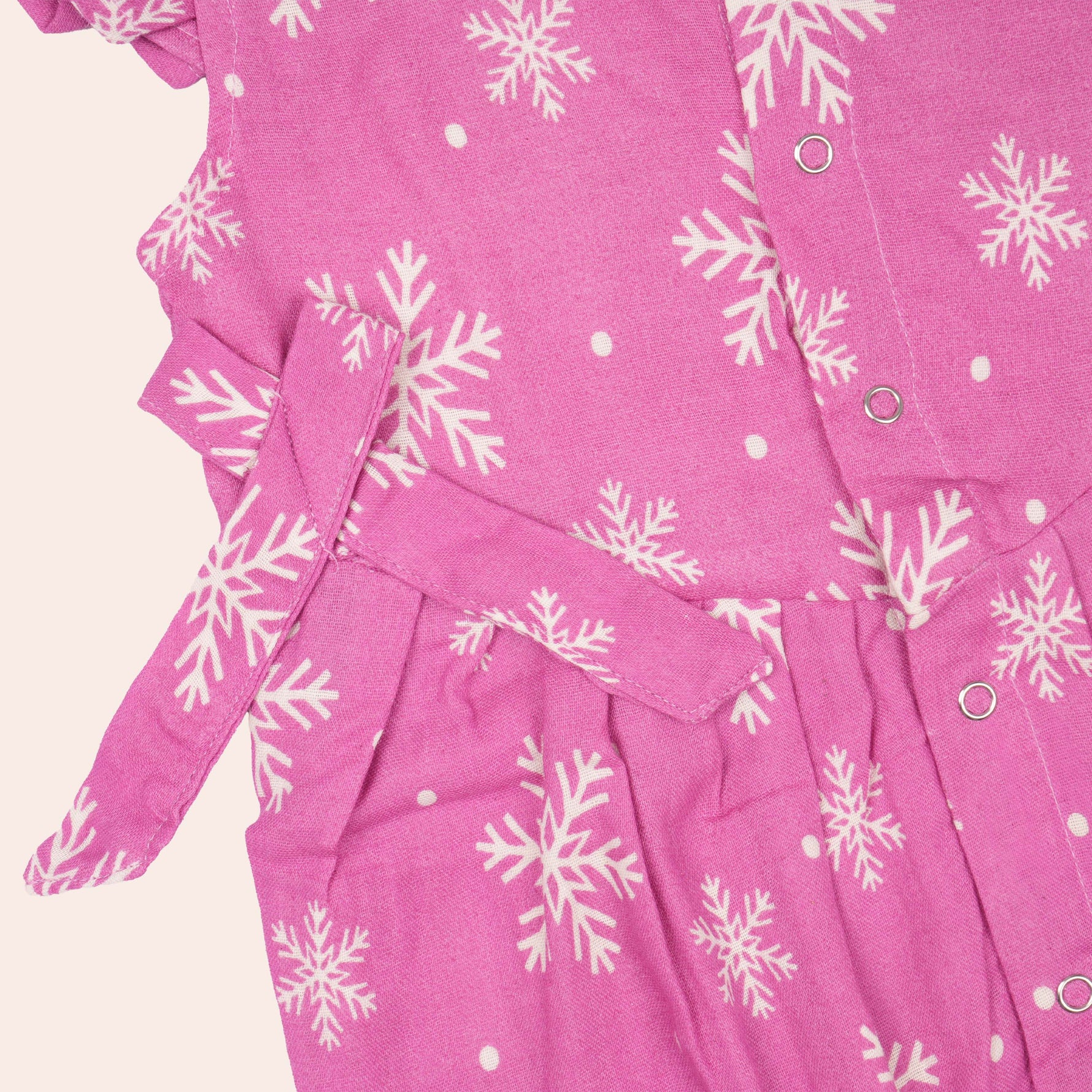 Baby girl in pink muslin printed romper with frill sleeves from Booon Babies, showing the cute, lightweight design.