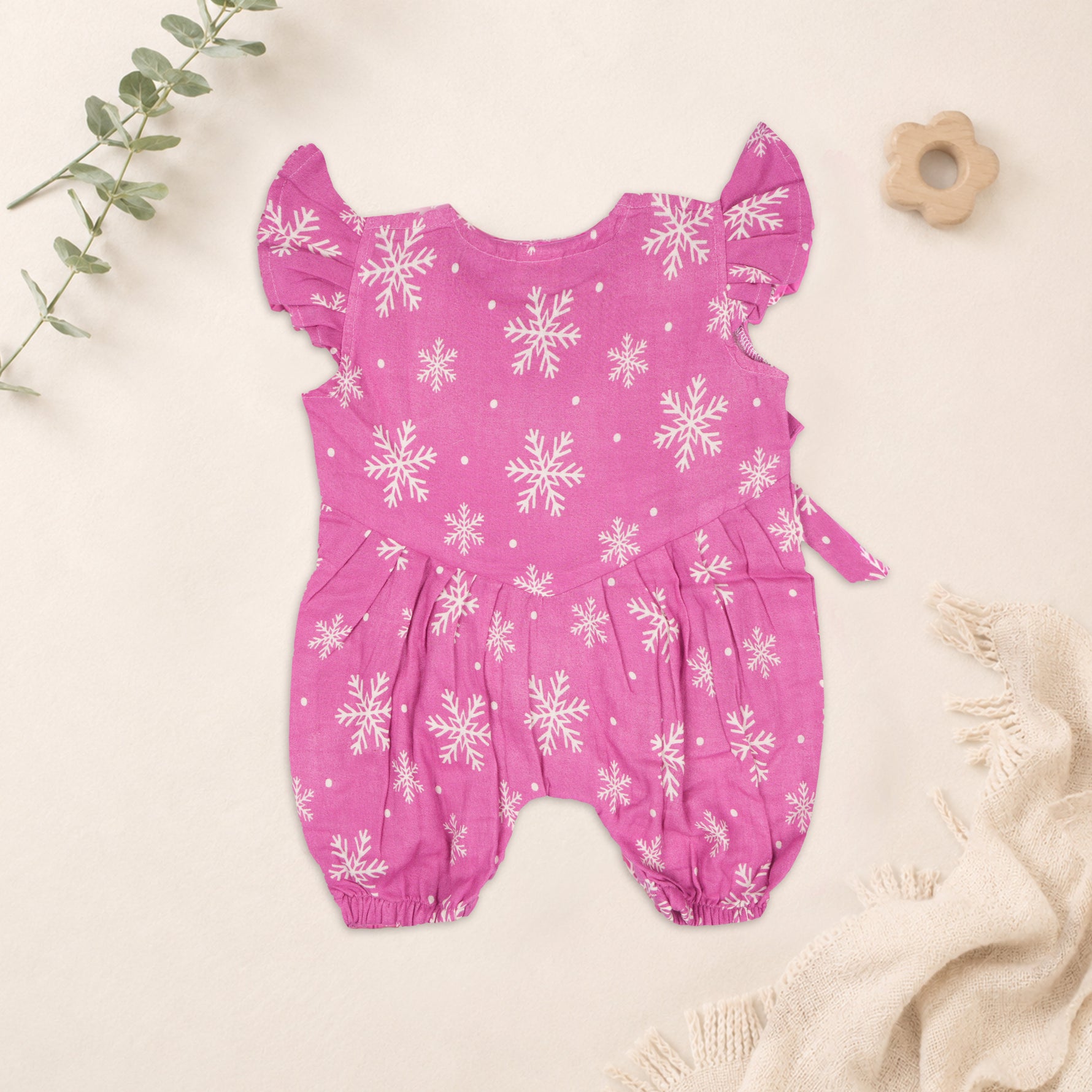 Baby girl baby romper in pink with muslin fabric, printed design and frill sleeves, by Booon Babies.