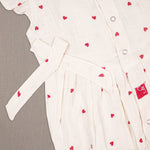 Baby girl in a printed muslin romper with frill sleeves from Boon Babies, showcasing soft fabric and adorable design.