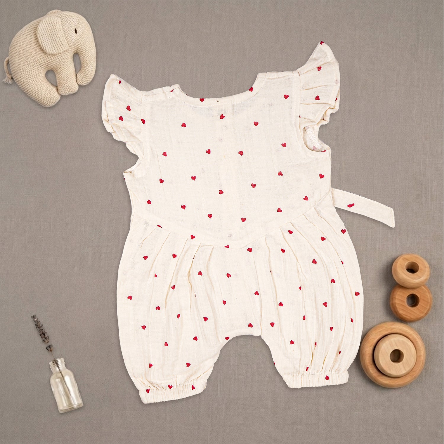 Baby girl in Booon Babies muslin printed romper with frill sleeves, featuring soft, breathable fabric and adorable design.
