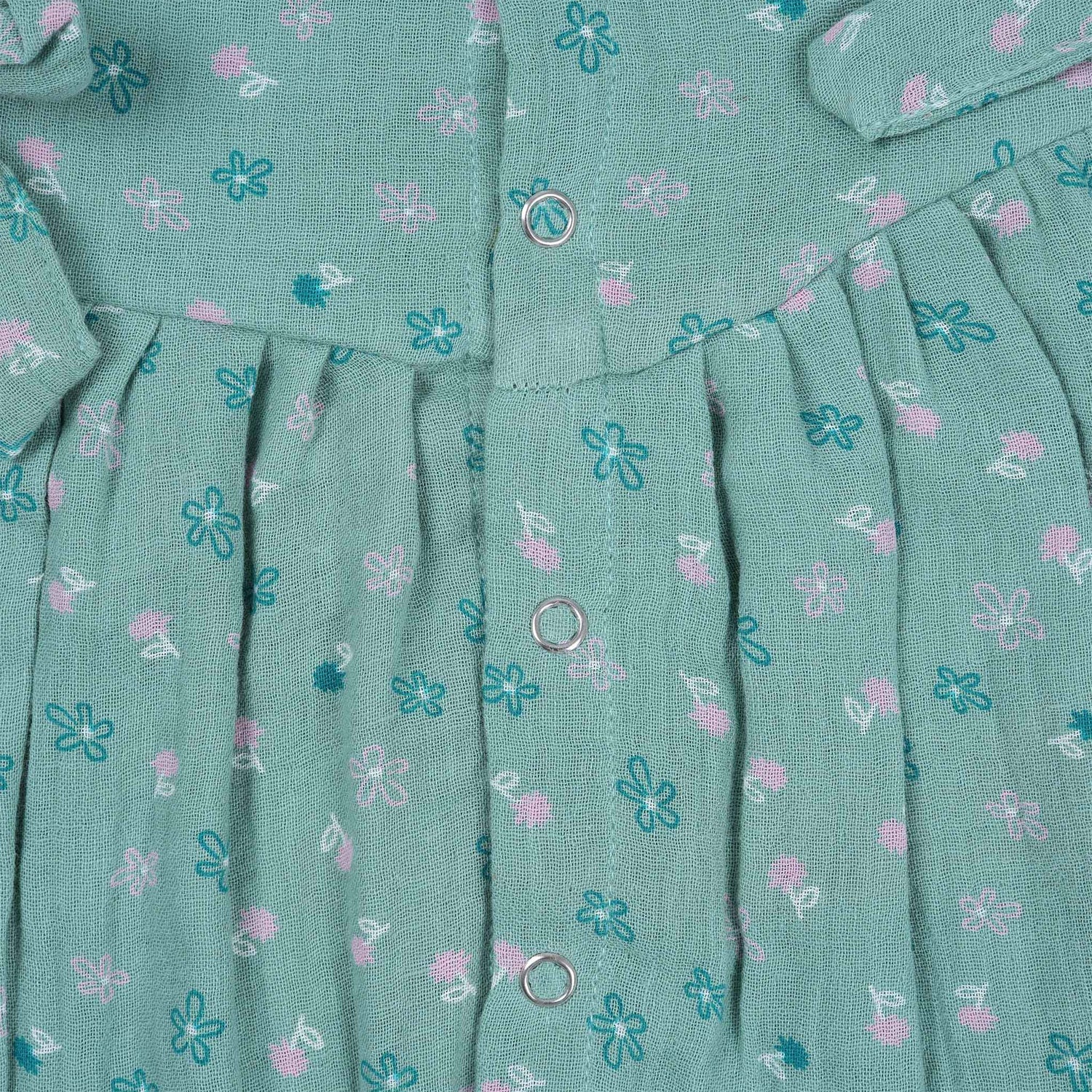 Teal blue baby romper with white floral prints, flutter sleeves, and side bows made from breathable crinkled muslin – designed for babies aged 0–12 months by Boon Babies, Coimbatore.