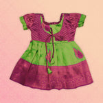 Girl wearing a green and pink tissue silk Pattu Pavadai ethnic frock by Boon Babies, showcasing traditional Indian attire.
