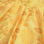 Sunshine yellow sleeveless slub cotton frock for baby girls with all-over orange floral print and pleated skirt, displayed flat on a white fur background with floral basket hanger.