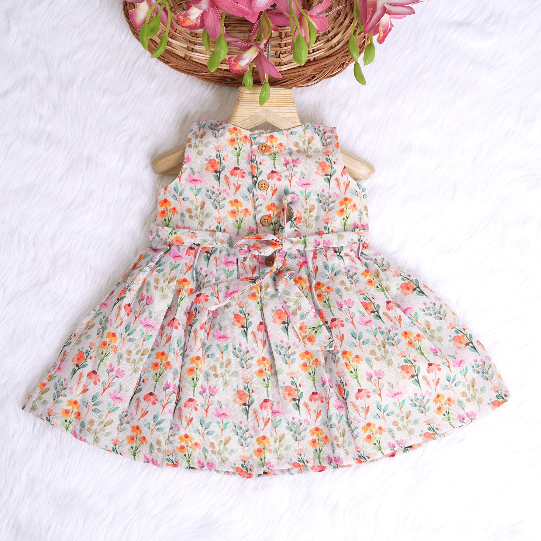 Baby girl in a white sleeveless floral frock made of slub cotton, designed for 6 months to 5 years – part of the Boon Babies kidswear collection in Coimbatore.
