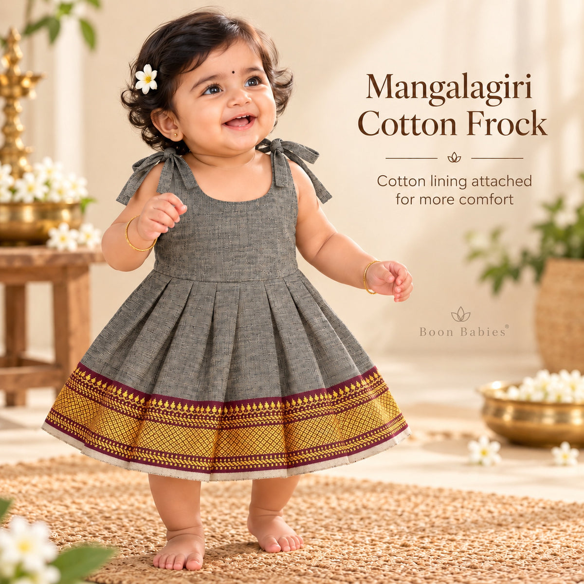 Baby girl wearing charcoal grey Mangalagiri cotton tie-shoulder frock with maroon and gold woven border