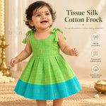 Baby girl wearing green tissue silk cotton knot frock with turquoise border and gold woven motifs