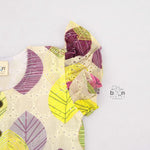 Baby girls hakoba frill frock with leaf print in yellow, purple & pink (NB–24M). Soft cotton, frill sleeves & button-down style – comfy & stylish.
