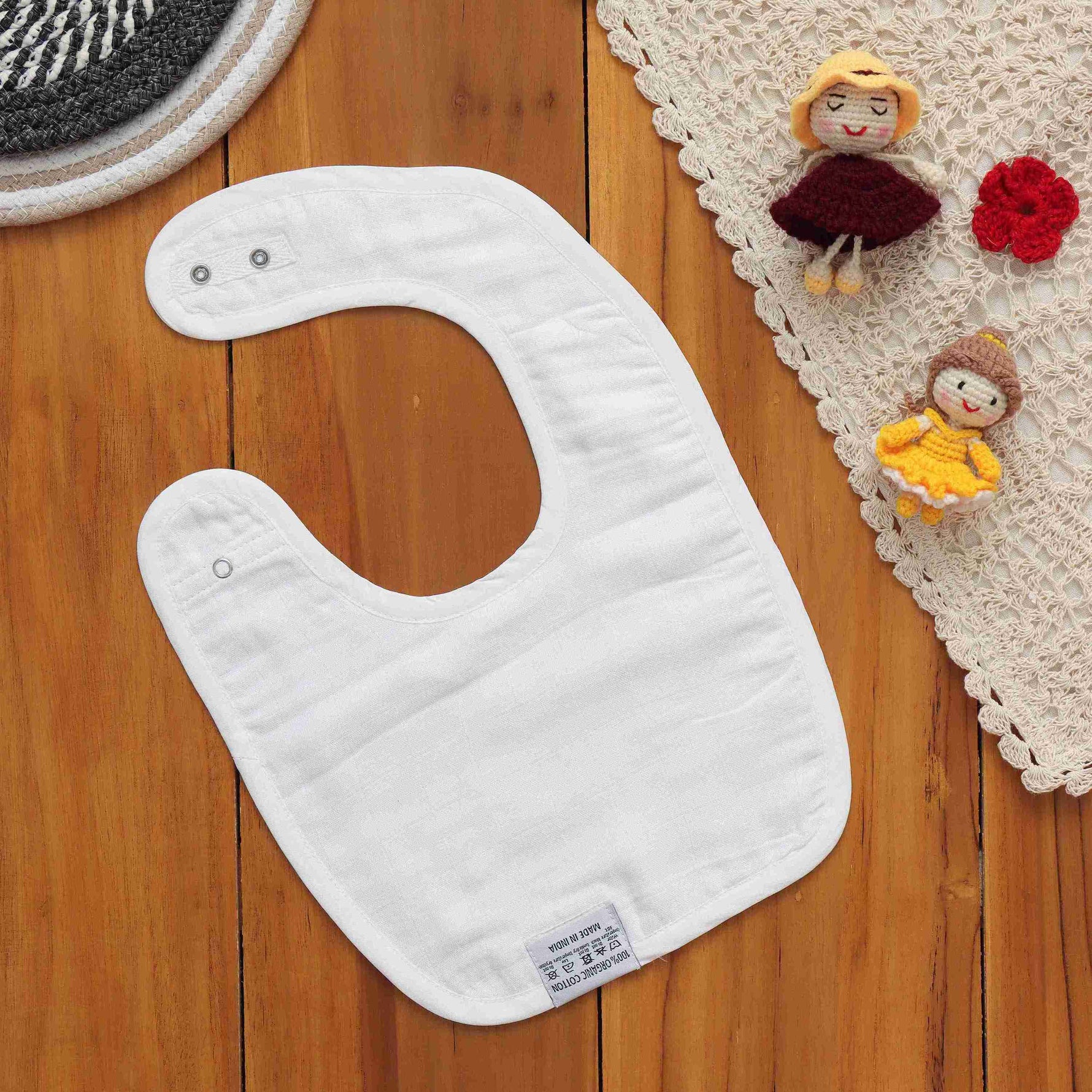 Breathable muslin baby bib with leafy print and snap closure. Skin-friendly and perfect for daily mess-free moments.