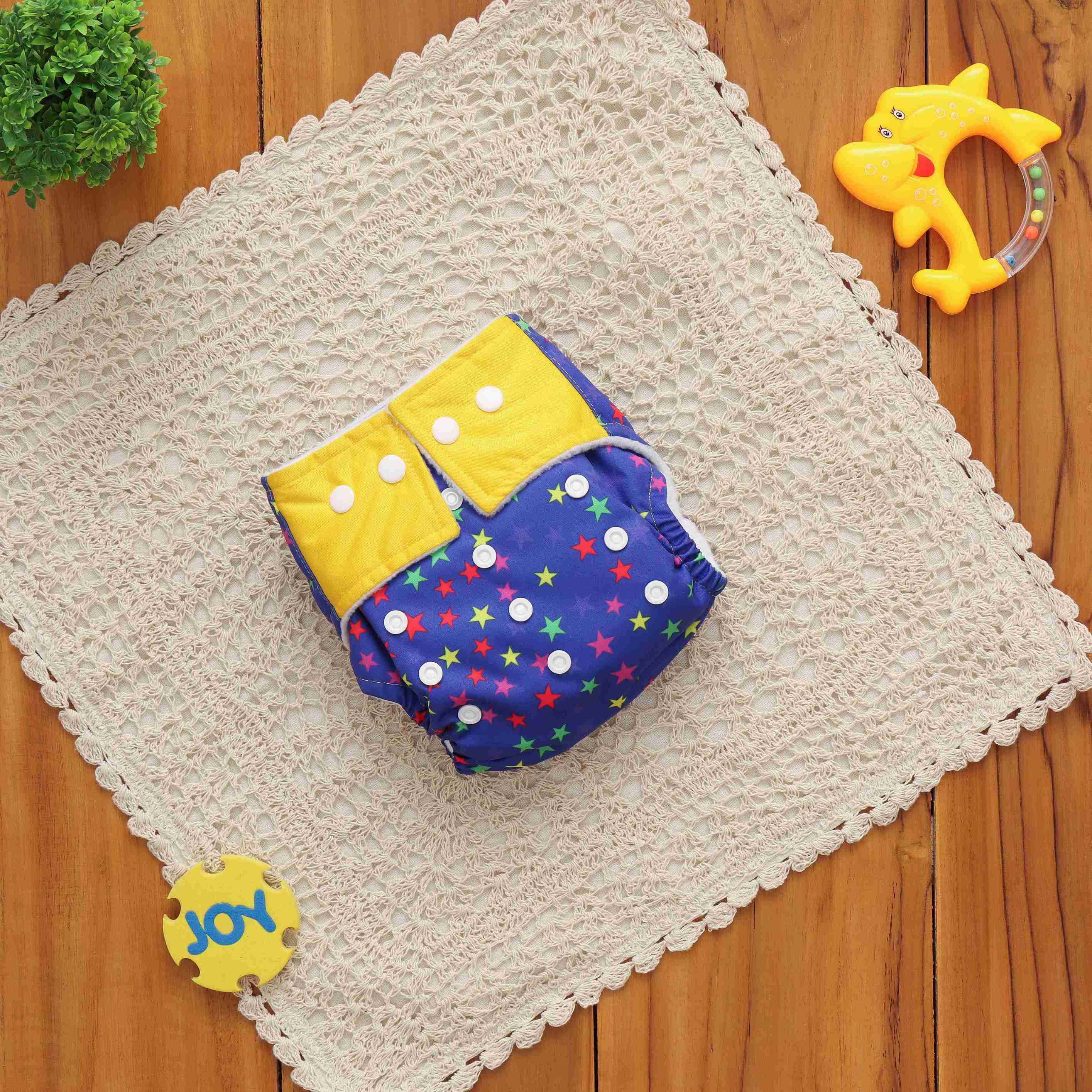 Adjustable reusable cloth diaper by Boon Babies in navy blue with starry print, suitable for babies up to 17kg, made of microfiber.