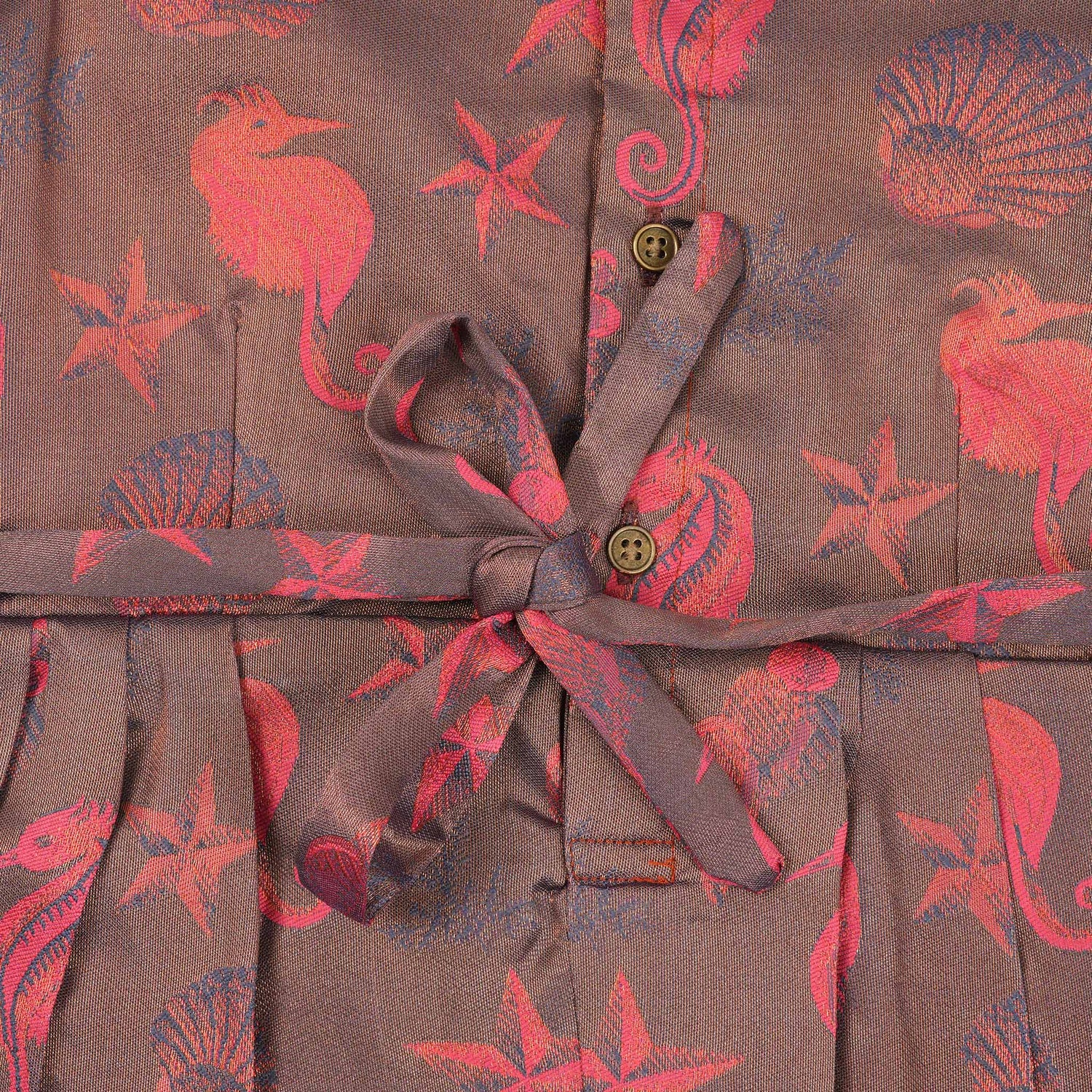 Traditional silk ethnic frock in Rani Pink and Brown for girls aged 1 to 5 years. Features zari motifs and puff sleeves – ideal for weddings and festivals.