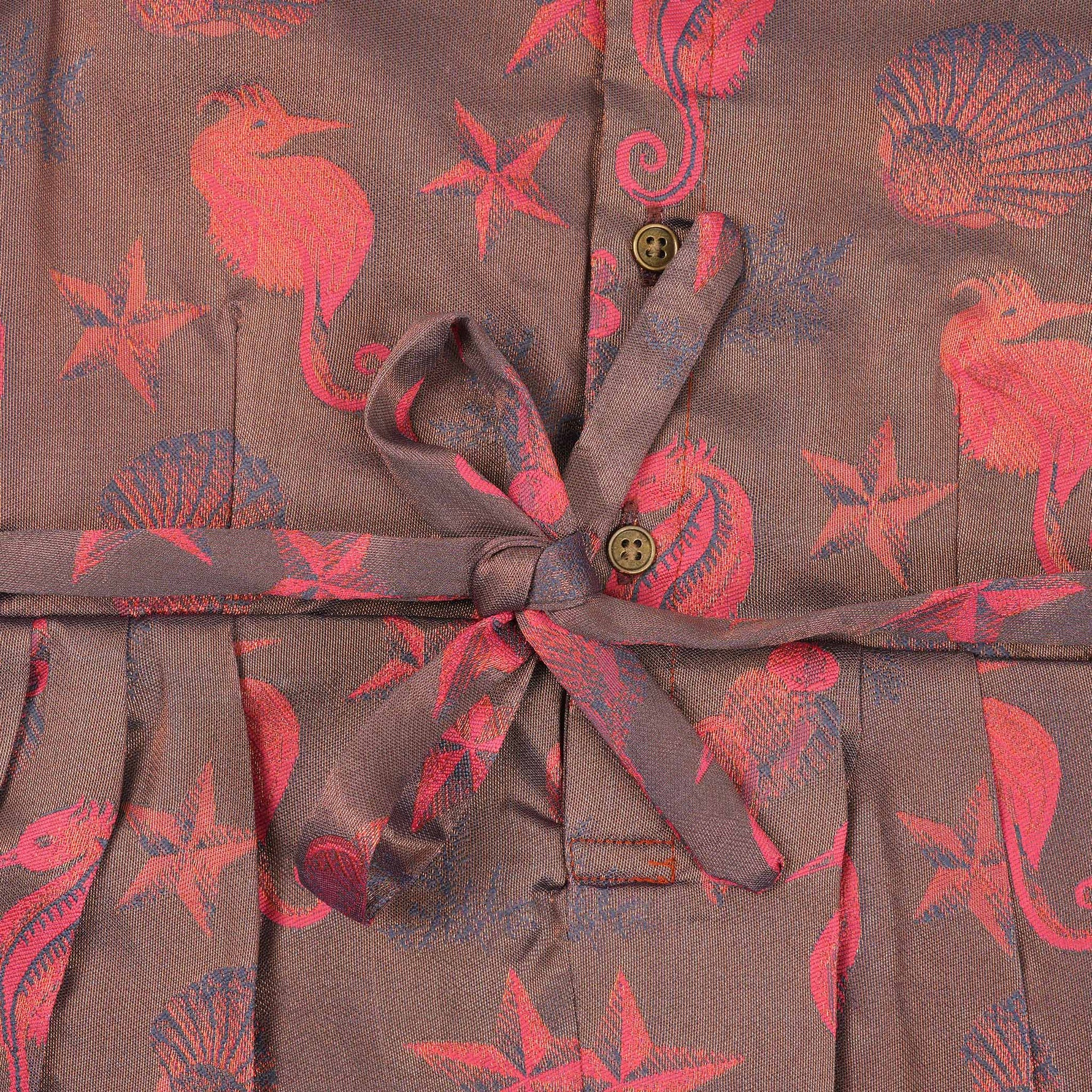 Traditional silk ethnic frock in Rani Pink and Brown for girls aged 1 to 5 years. Features zari motifs and puff sleeves – ideal for weddings and festivals.