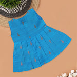 Blue silk sleeveless ethnic frock for baby girls with wooden buttons and traditional motifs, laid flat on a beige background with rustic and floral decor.