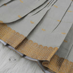 Festive grey silk Onam knot frock with triangle yoke design & zari border. Perfect for baby girls (0–12M).