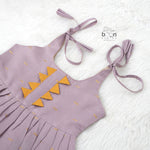 Lavender silk Onam knot frock with zari border & triangle yoke. Ages 0–12M. Perfect festive outfit for baby girls.