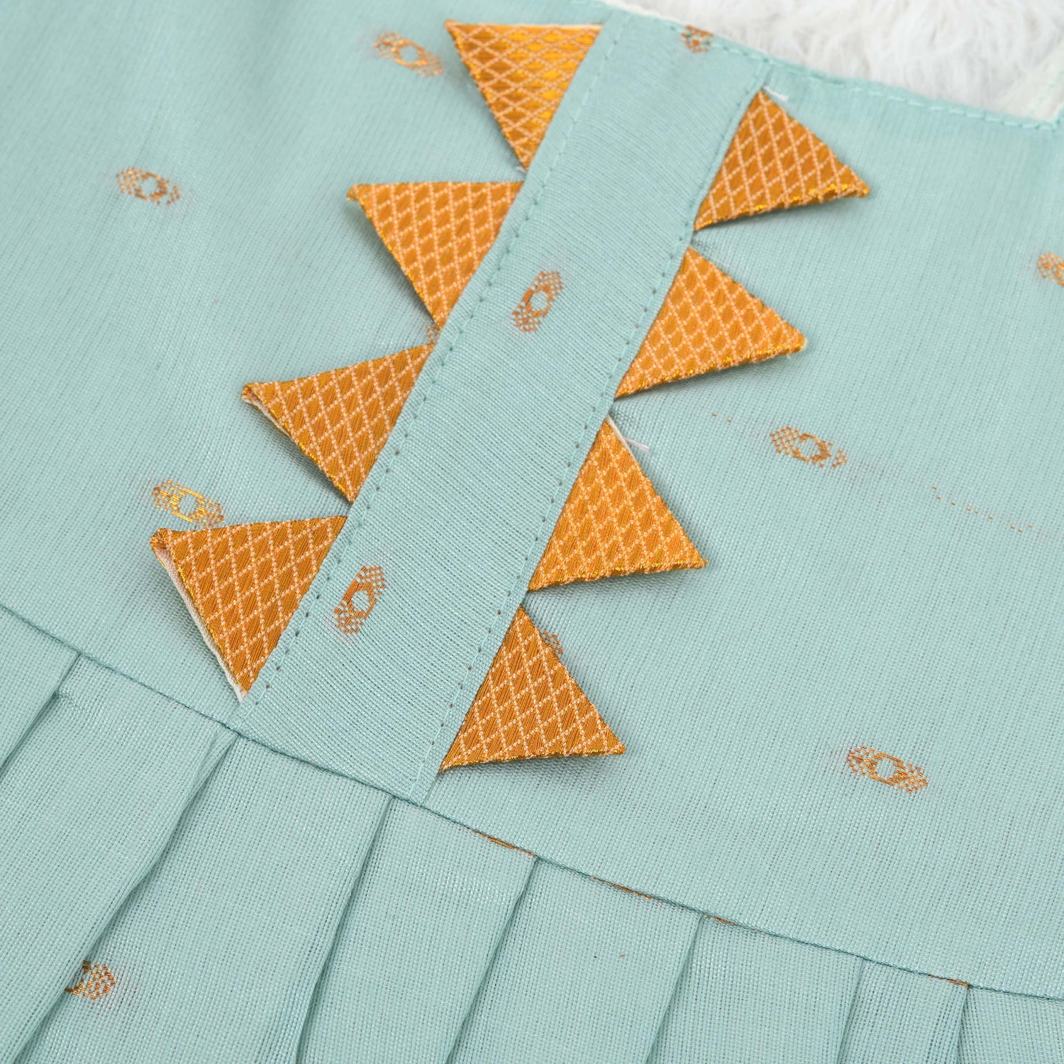 Mint green silk Onam knot frock with triangle yoke, zari border & knot straps. Ideal festive outfit for baby girls (0–12M).