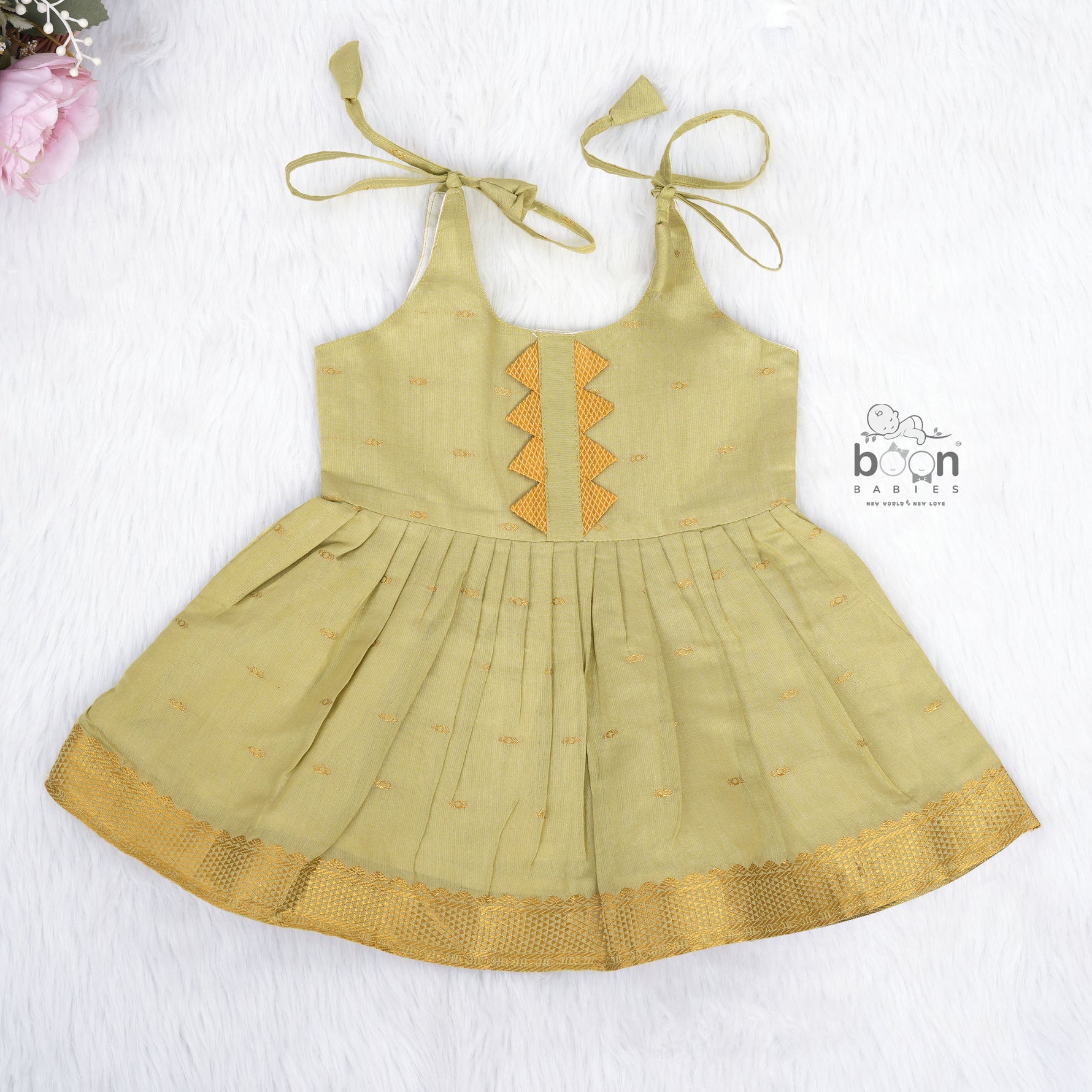 Olive green silk Onam knot frock with zari border & triangle yoke. Ages 0–12M. Perfect festive outfit for baby girls.