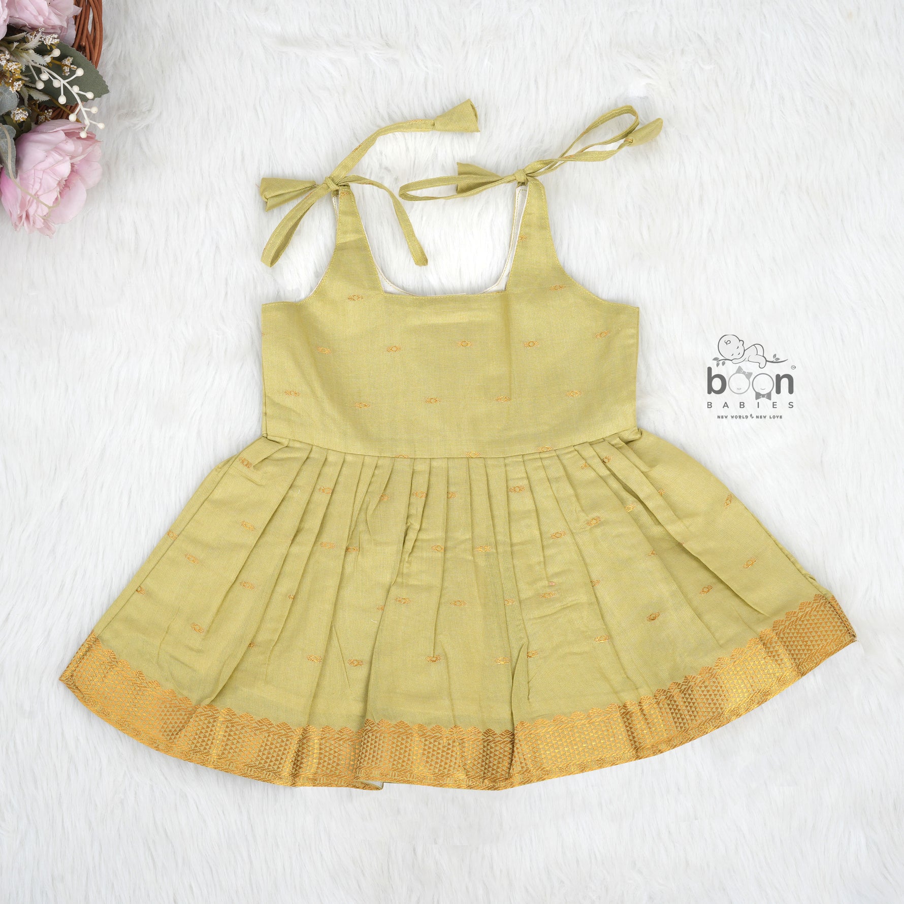 Olive green silk Onam knot frock with zari border & triangle yoke. Ages 0–12M. Perfect festive outfit for baby girls.