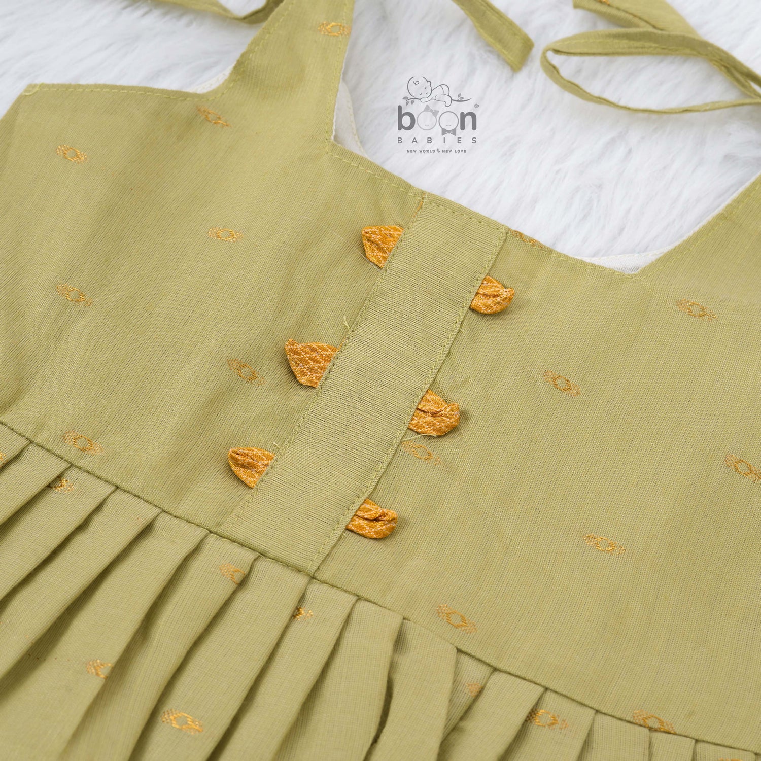 Olive green silk knot frock with zari border for baby girls (0–12 months). Festive, elegant & comfortable for Onam celebrations.
