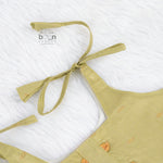 Olive green silk knot frock with zari border for baby girls (0–12 months). Festive, elegant & comfortable for Onam celebrations.
