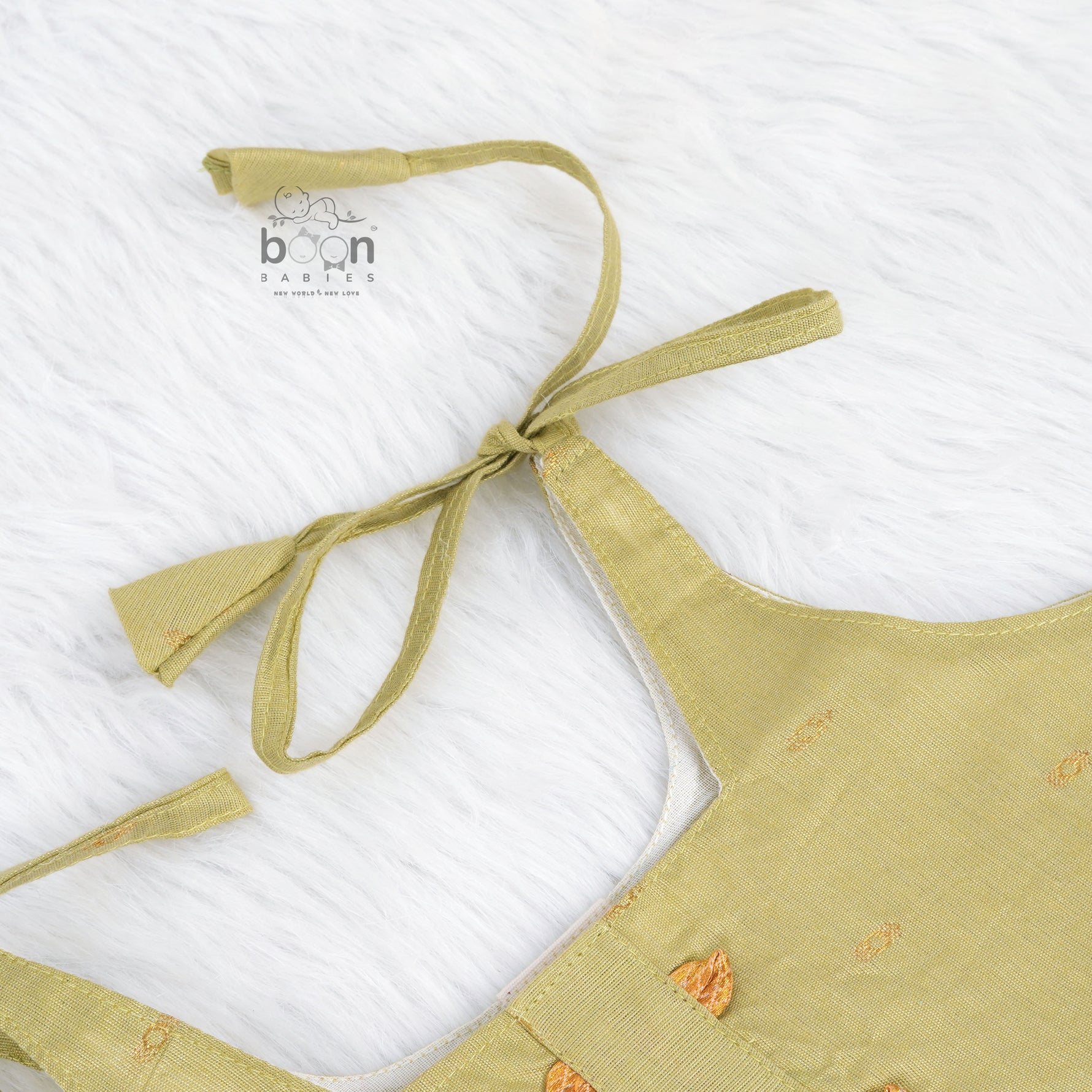 Olive green silk knot frock with zari border for baby girls (0–12 months). Festive, elegant & comfortable for Onam celebrations.
