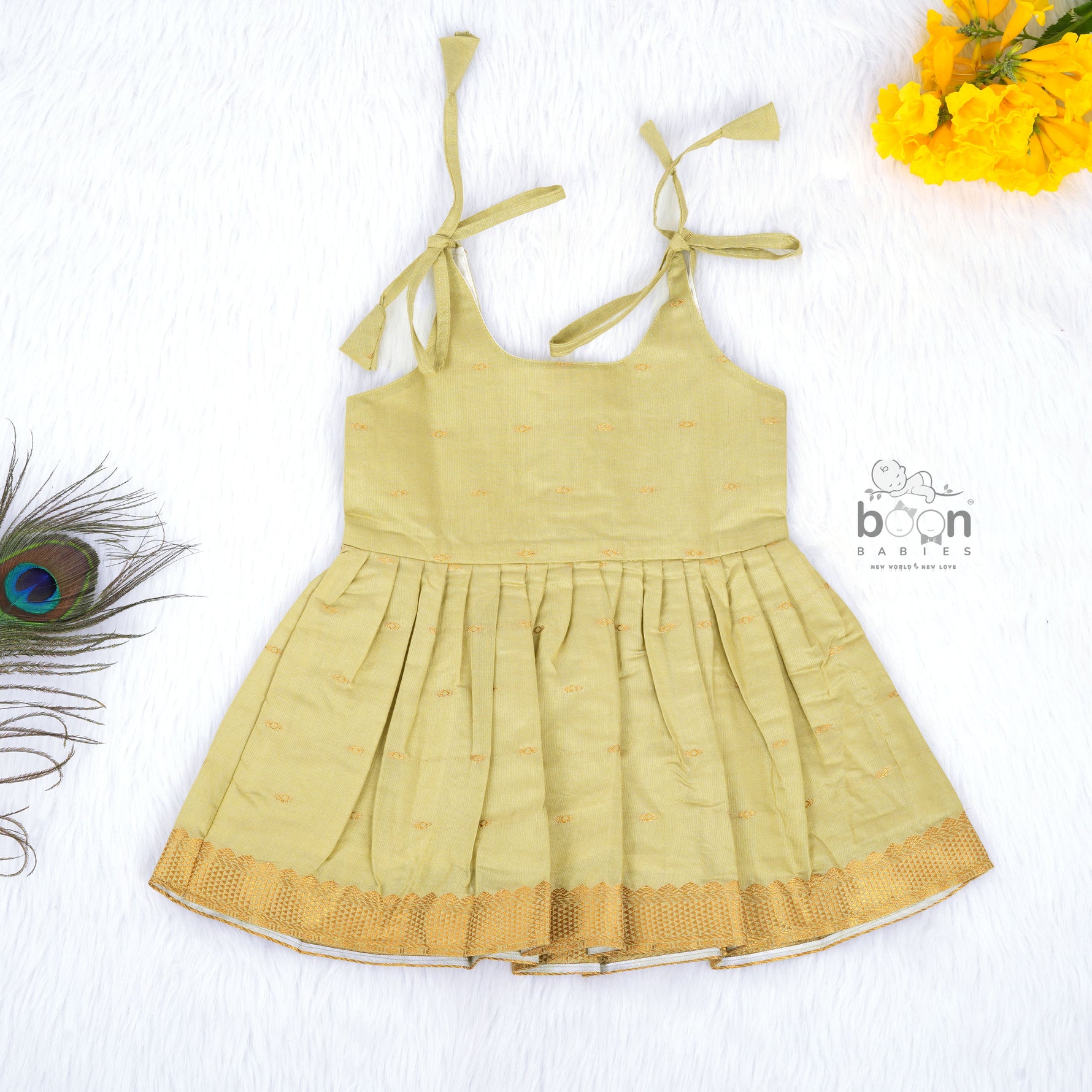Olive green silk knot frock with zari border for baby girls (0–12 months). Festive, elegant & comfortable for Onam celebrations.
