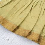 Olive green silk knot frock with zari border for baby girls (0–12 months). Festive, elegant & comfortable for Onam celebrations.
