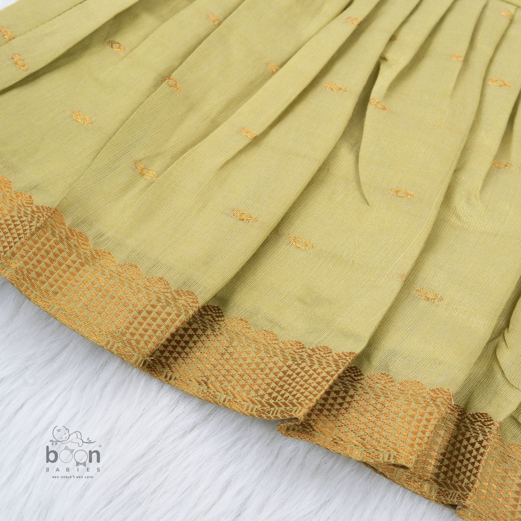 Olive green silk knot frock with zari border for baby girls (0–12 months). Festive, elegant & comfortable for Onam celebrations.
