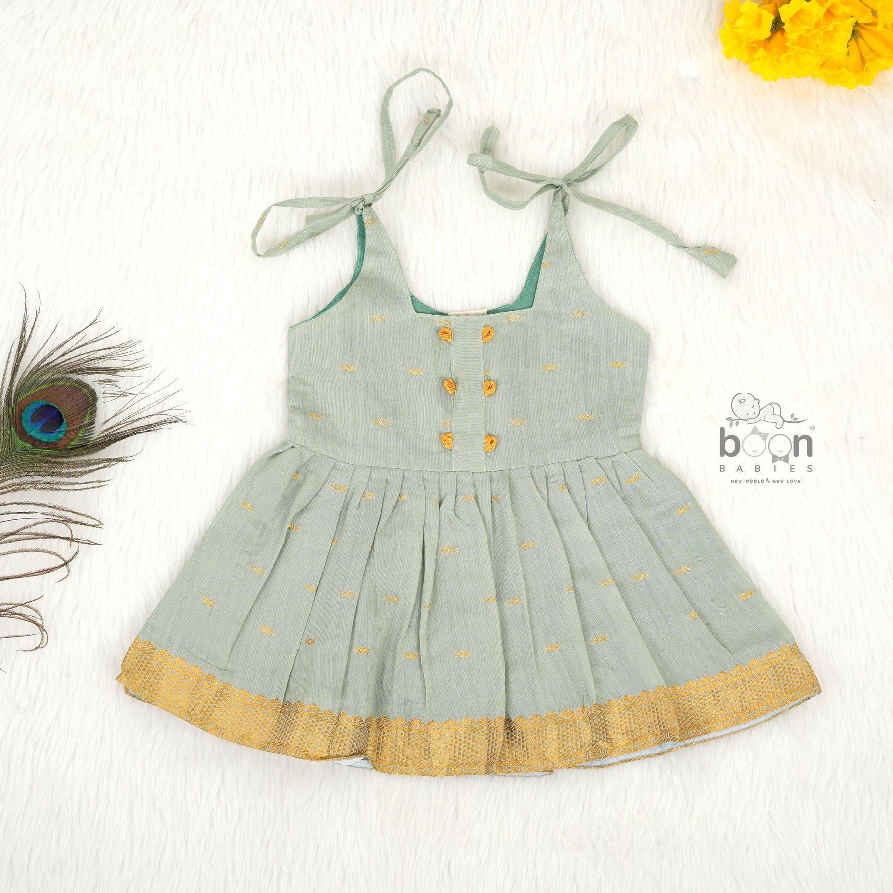 Festive silk knot frock for baby girls (6–12 months) with zari border & tie-up straps. Perfect for Onam & traditional celebrations.
