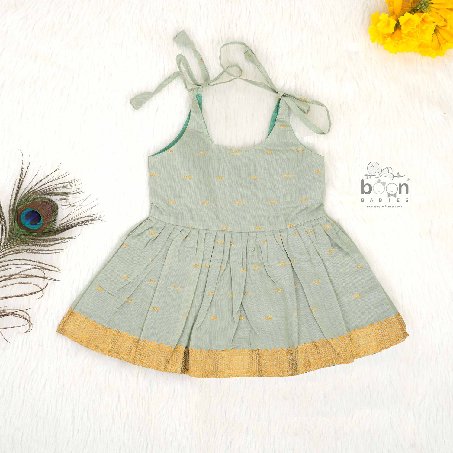 Festive silk knot frock for baby girls (6–12 months) with zari border & tie-up straps. Perfect for Onam & traditional celebrations.
