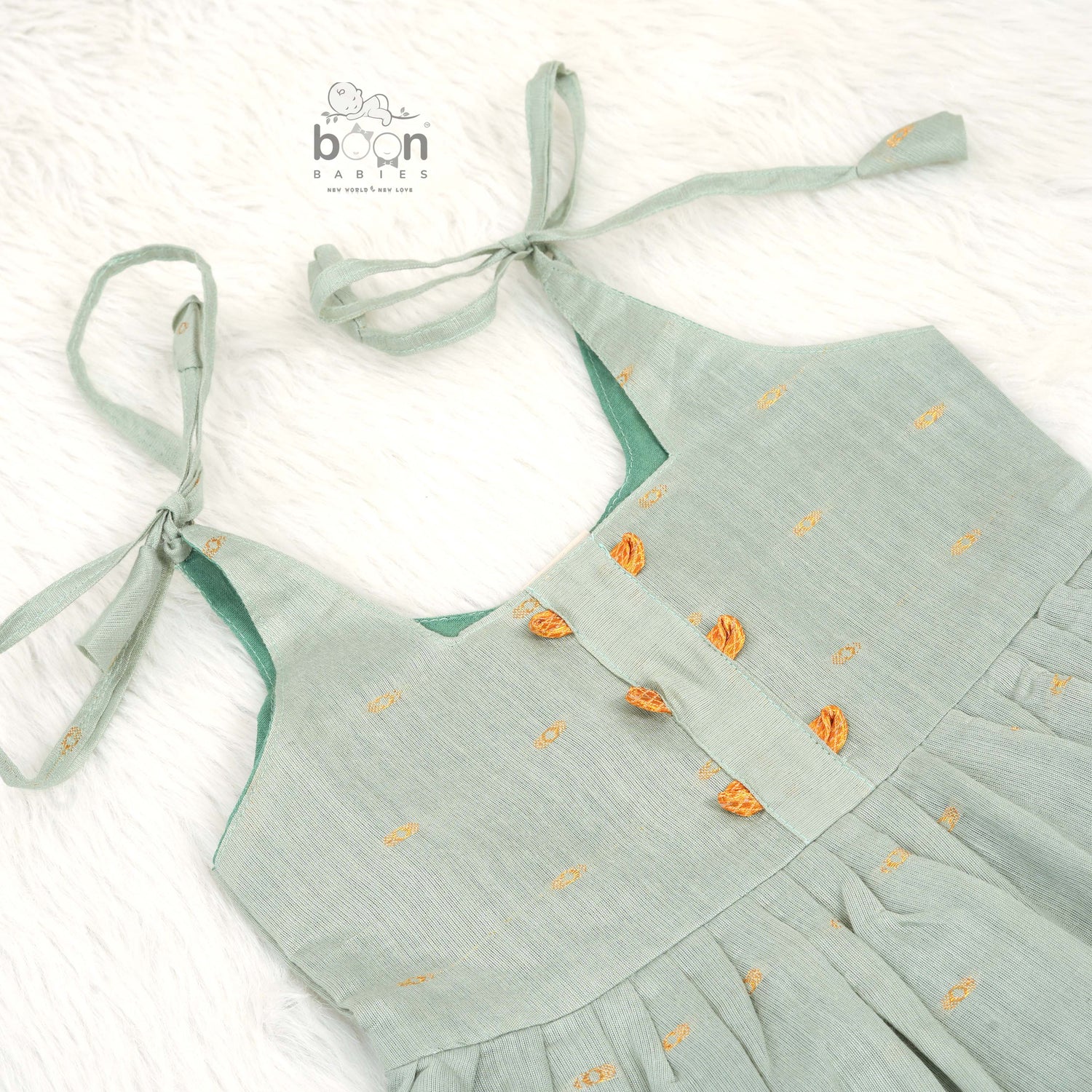 Festive silk knot frock for baby girls (6–12 months) with zari border & tie-up straps. Perfect for Onam & traditional celebrations.

