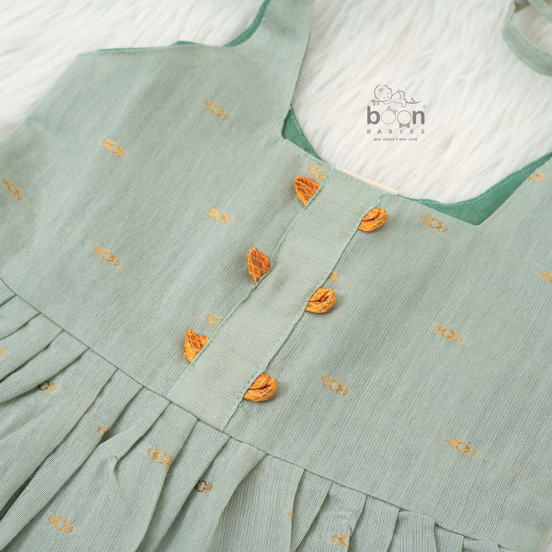 Festive silk knot frock for baby girls (6–12 months) with zari border & tie-up straps. Perfect for Onam & traditional celebrations.
