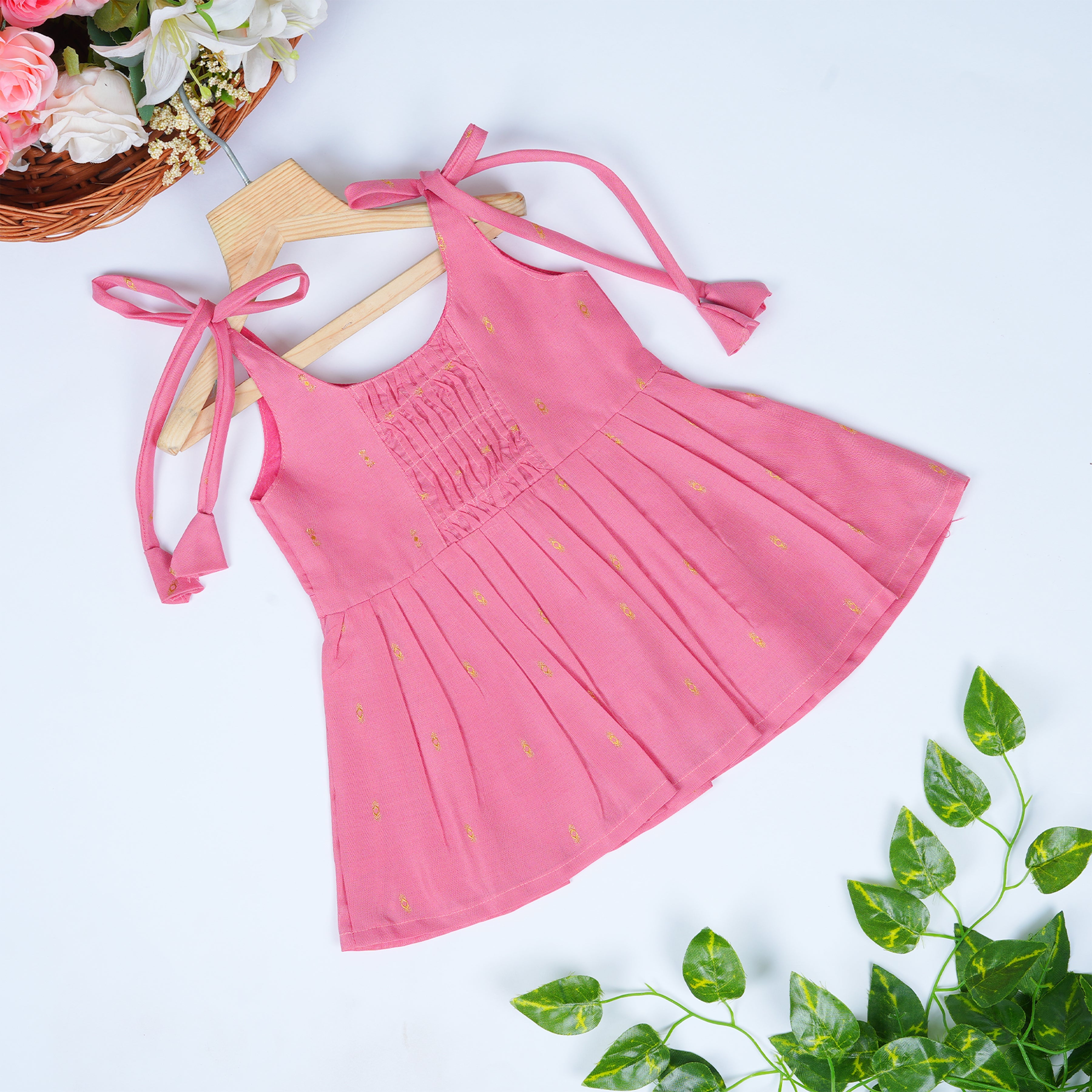 Premium pink silk knot frock with gathered front design, golden motifs & inner lining. Perfect for outdoor and elegant daily wear.