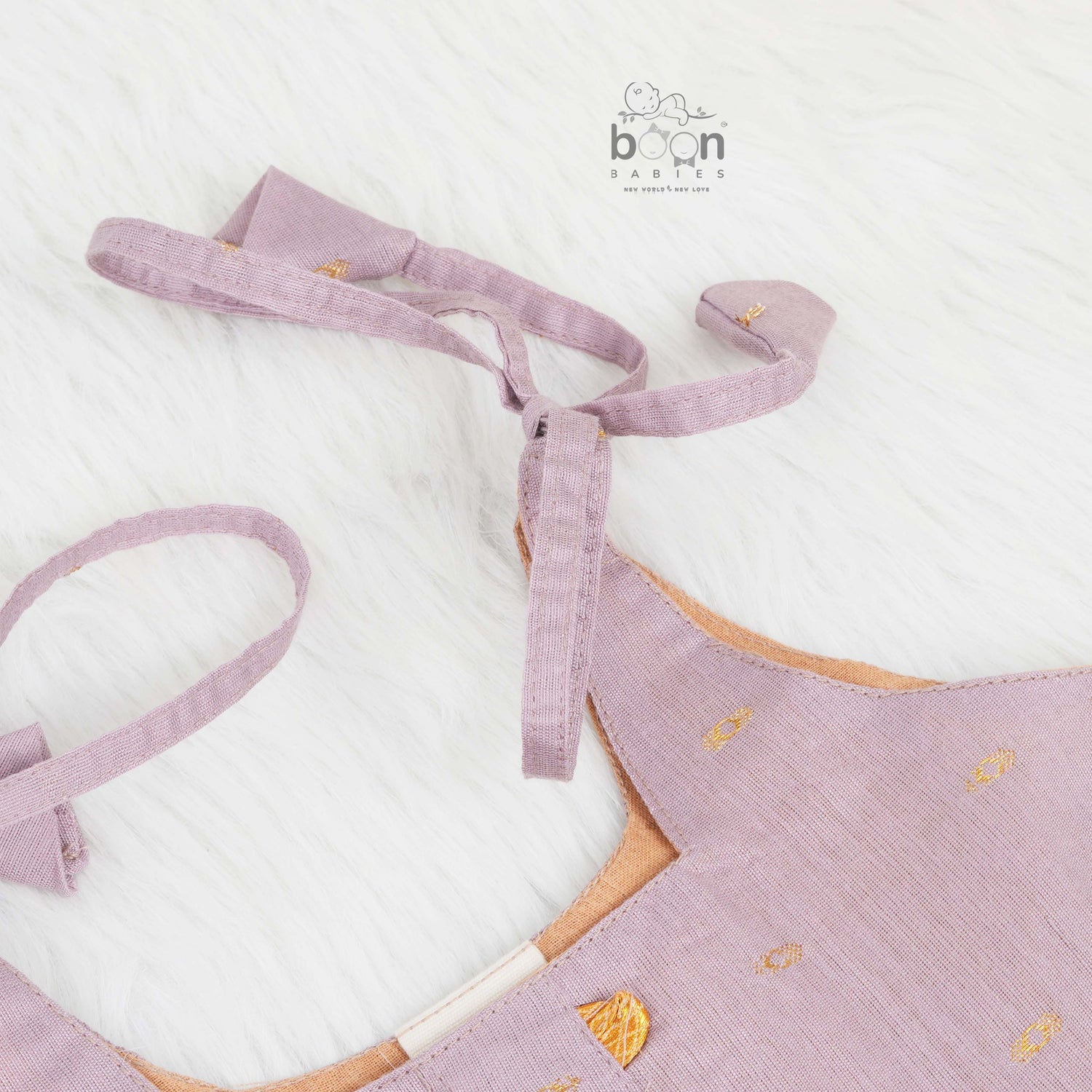 Elegant mauve silk knot frock with zari border for baby girls (0–12 months). Festive & comfortable – perfect for Onam celebrations.