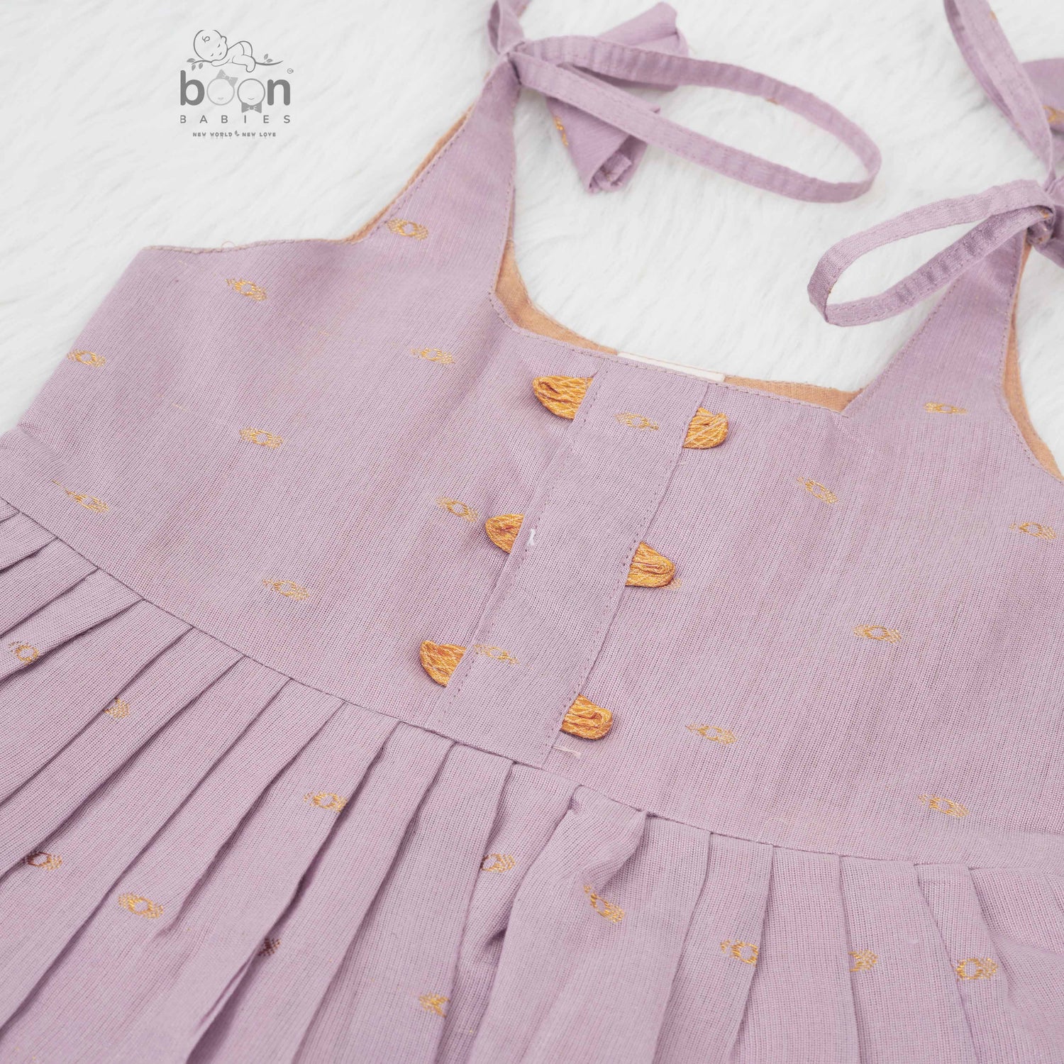 Elegant mauve silk knot frock with zari border for baby girls (0–12 months). Festive & comfortable – perfect for Onam celebrations.